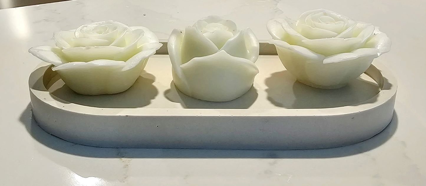 3 rose candles in a tray.